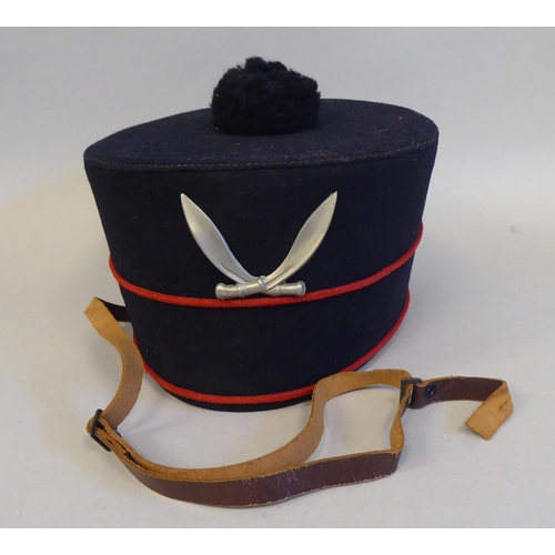 29 - A military style black pill box hat with red piping  bears a Hobson & Sons (London) label and br... 