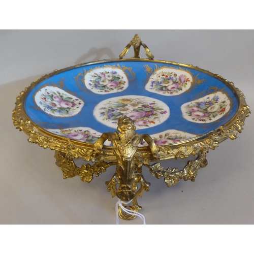 3 - A 19thC Serves porcelain shallow dish, decorated with gilded vignette studies of mixed flora, on a p... 