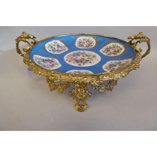 3 - A 19thC Serves porcelain shallow dish, decorated with gilded vignette studies of mixed flora, on a p... 