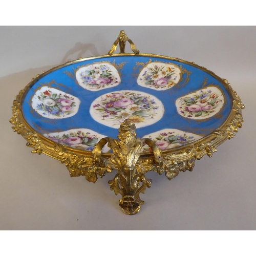 3 - A 19thC Serves porcelain shallow dish, decorated with gilded vignette studies of mixed flora, on a p... 