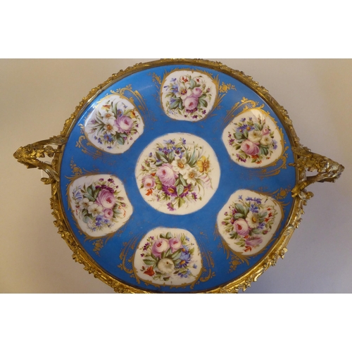 3 - A 19thC Serves porcelain shallow dish, decorated with gilded vignette studies of mixed flora, on a p... 