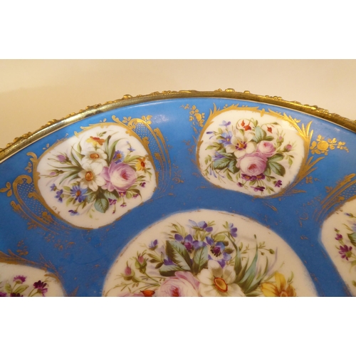 3 - A 19thC Serves porcelain shallow dish, decorated with gilded vignette studies of mixed flora, on a p... 