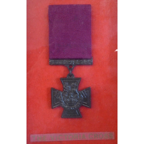 31 - Mixed military related items: to include a replica Victoria Cross; and a painted diecast standing fi... 