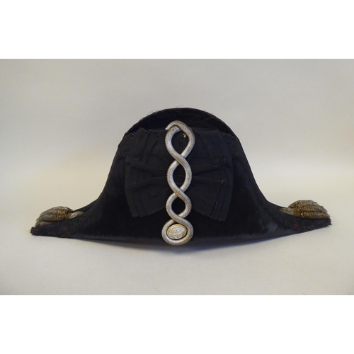 34 - A naval black cocked hat with braid and a feather plume, size 7, in a painted tinplate box (Please N... 