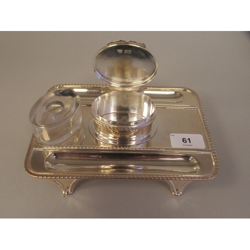 61 - A Georgian style silver standish, the rectangular tray base with a gadrooned border, two pen channel... 