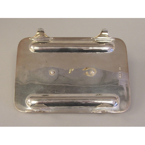 61 - A Georgian style silver standish, the rectangular tray base with a gadrooned border, two pen channel... 