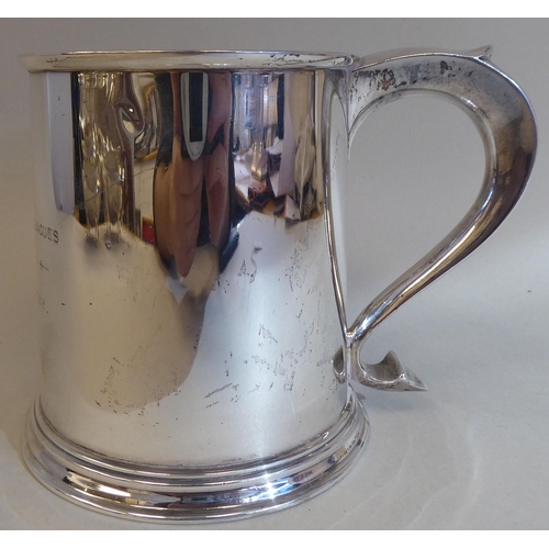 7 - A 19thC style silver mug with an applied wire rim and hollow S-shape handle, on a stepped footrim&nb... 