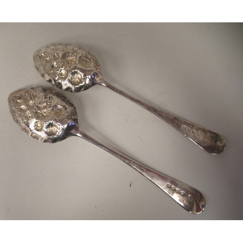 73 - A pair of George III silver and parcel gilt Old English pattern berry spoons with foliate engraved s... 