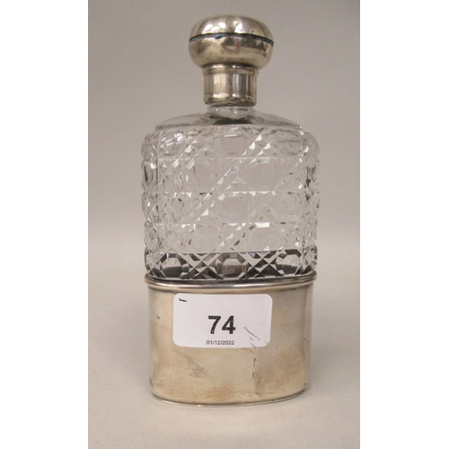 74 - An Edwardian cut glass shouldered hip flask with a silver sleeve cup and threaded mushroom shaped ca... 