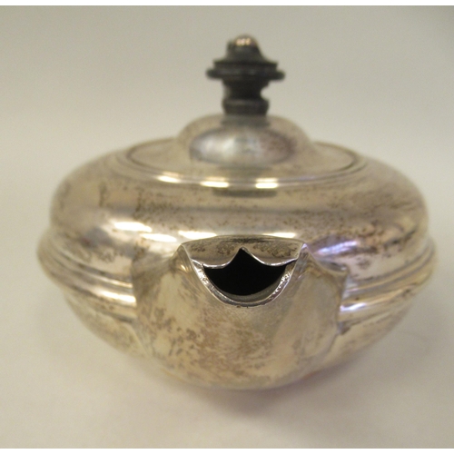 77 - An Edwardian silver circular teapot of squat, bulbous form with a swept spout, insulated handle and ... 