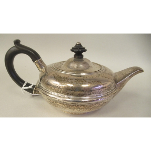 77 - An Edwardian silver circular teapot of squat, bulbous form with a swept spout, insulated handle and ... 