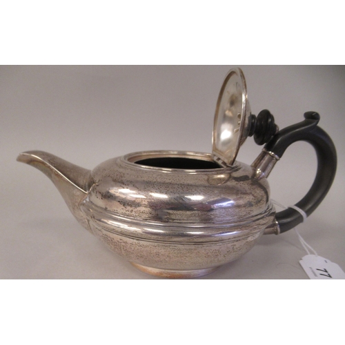 77 - An Edwardian silver circular teapot of squat, bulbous form with a swept spout, insulated handle and ... 