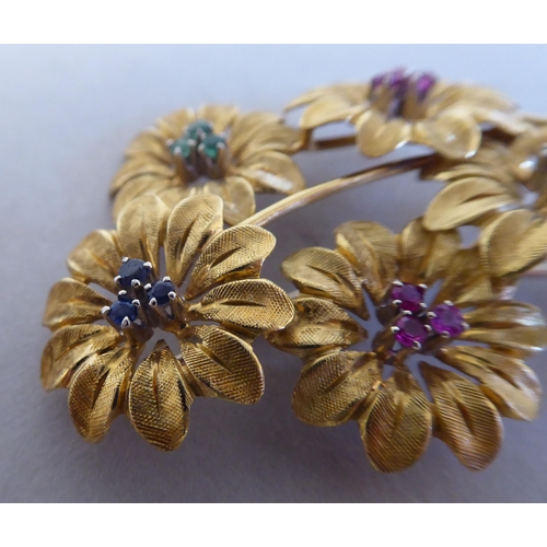 86 - An 18ct textured gold floral brooch, set with coloured stones 