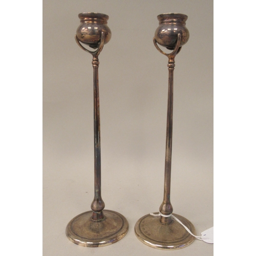 96 - A pair of silver candlesticks, in the manner of Tiffany, each comprising a cauldron shaped socket in... 