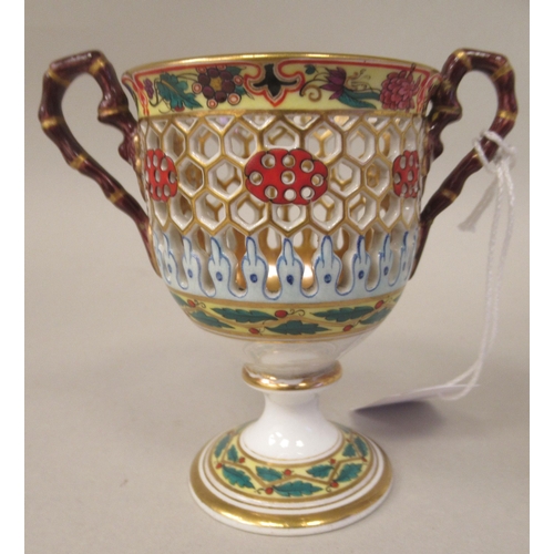 99 - A Chamberlain's Worcester reticulated twin handled porcelain pedestal cup and saucer, brightly decor... 