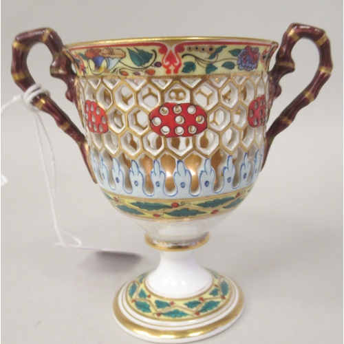 99 - A Chamberlain's Worcester reticulated twin handled porcelain pedestal cup and saucer, brightly decor... 