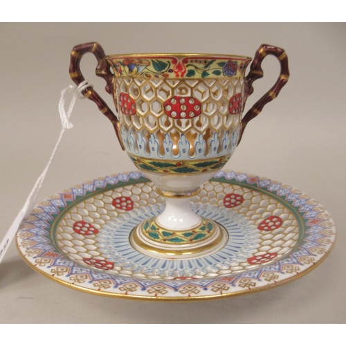 99 - A Chamberlain's Worcester reticulated twin handled porcelain pedestal cup and saucer, brightly decor... 