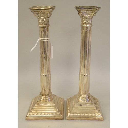 9 - A pair of modern loaded silver candlesticks with detachable bead bordered sconces, Corinthian capita... 