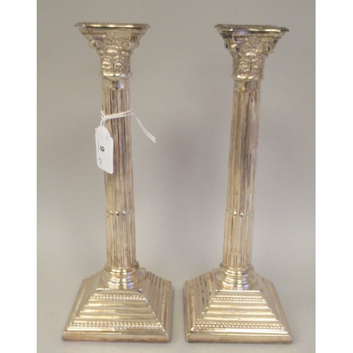 9 - A pair of modern loaded silver candlesticks with detachable bead bordered sconces, Corinthian capita... 