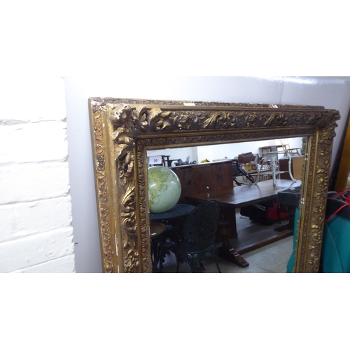 50 - A 19thC mirror, set in a foliate, floral and shell moulded gilt frame  55