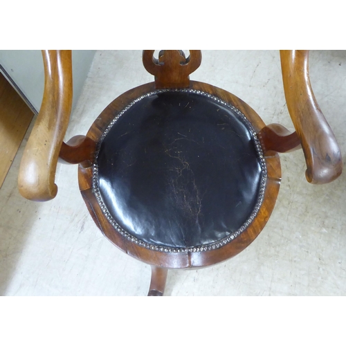 54 - A late Victorian mahogany framed, horseshoe shape back desk chair with a simply carved splat and swe... 