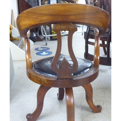 54 - A late Victorian mahogany framed, horseshoe shape back desk chair with a simply carved splat and swe... 