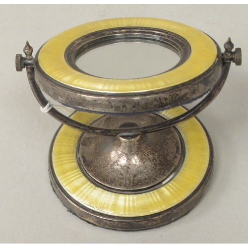 59 - A silver and engine turned, yellow enamel dressing table mirror of small proportions, the circular p... 