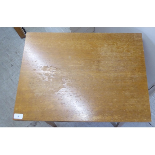 8 - A mid 20thC light oak cased sewing table, raised on square, tapered legs  31