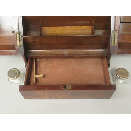 160 - An early 20thC walnut veneered desktop stationary box, the cushion moulded, hinged top revealing a r... 