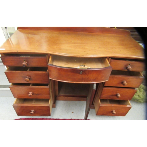 10 - A late Victorian mahogany bow front sideboard, the central, recessed cupboard, flanked by an arrange... 