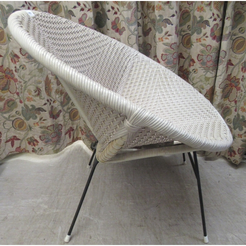 107 - A vintage design wicker effect tub chair, on tubular metal legs 