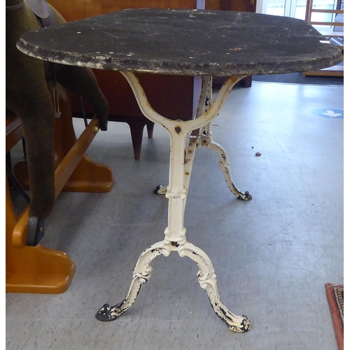 112 - A 20thC terrace table, the lozenge shape composition stone top, on a white painted cast iron underfr... 