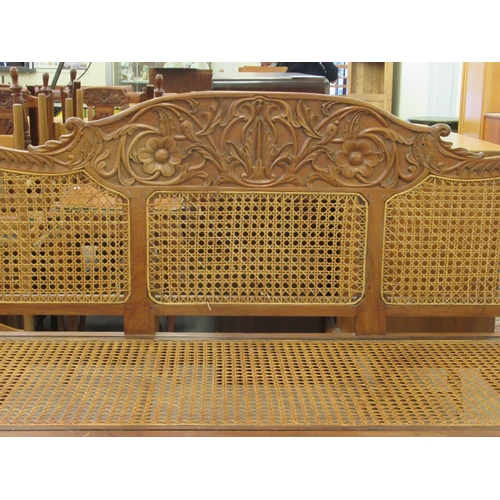 121 - A late 19thC Indian Colonial carved fruitwood framed scroll end settee with a woven split cane panel... 