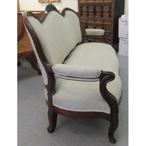 124 - A late Victorian mahogany framed salon settee with a grey fabric upholstered back and seat, raised o... 