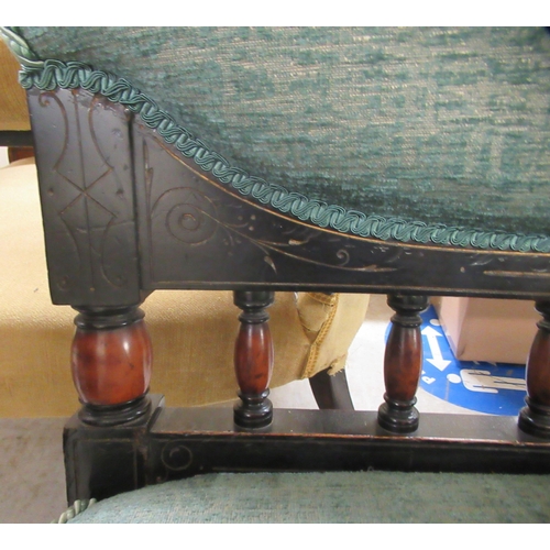 127 - An Edwardian ebonised framed two person salon chair, upholstered in a blue fabric, raised on turned ... 