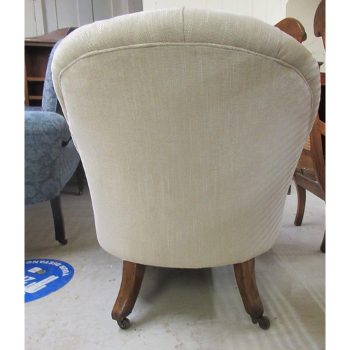 129 - A late Victorian walnut framed salon chair, upholstered in an oatmeal coloured fabric, raised on cab... 