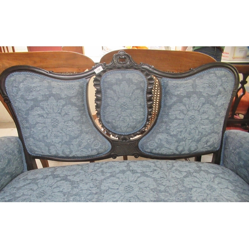 130 - A late Victorian ebonised framed two person salon settee with a blue fabric upholstered back and sea... 