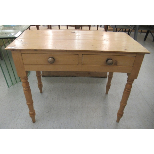 15 - An early 20thC waxed pine side table, the planked top over two inline drawers, raised on ring turned... 