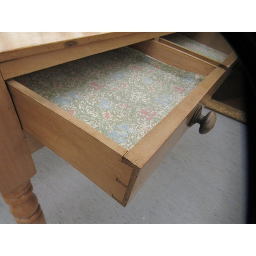 15 - An early 20thC waxed pine side table, the planked top over two inline drawers, raised on ring turned... 