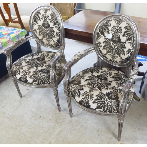 157 - A pair of modern French silvered framed open arm salon chairs, upholstered in floral patterned fabri... 