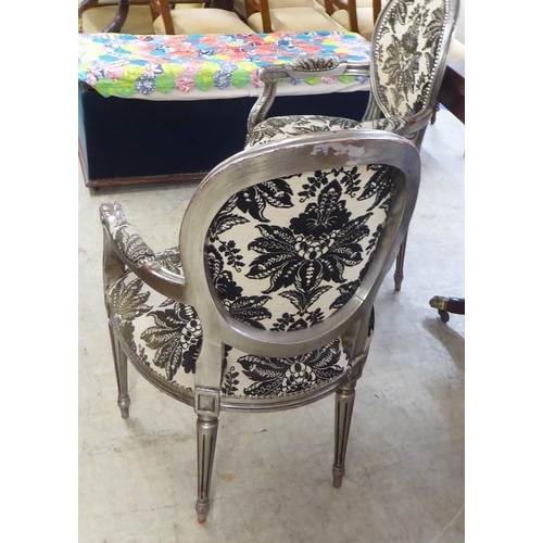 157 - A pair of modern French silvered framed open arm salon chairs, upholstered in floral patterned fabri... 