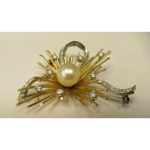 184 - A bi-coloured metal brooch, in a sunburst and ribbon style, set with a central cultured pearl, surro... 