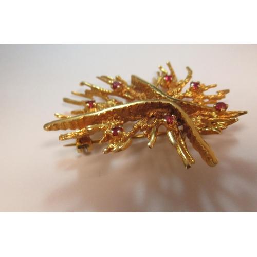 188 - A 9ct gold brooch, shaped as a coral structure with a central 'X', set with seven rubies