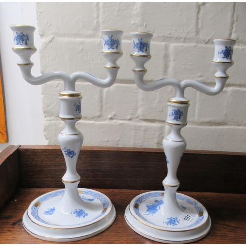 191 - A pair of Herend porcelain two branch candlesticks, decorated with blue floral sprigs  10.5