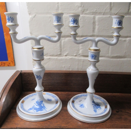 191 - A pair of Herend porcelain two branch candlesticks, decorated with blue floral sprigs  10.5