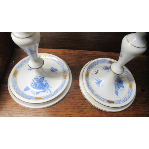 191 - A pair of Herend porcelain two branch candlesticks, decorated with blue floral sprigs  10.5