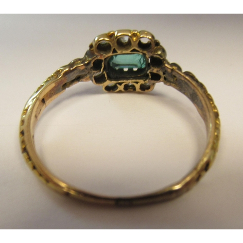 193 - A yellow metal cluster ring, set with a central emerald, surrounded by diamonds (two missing)