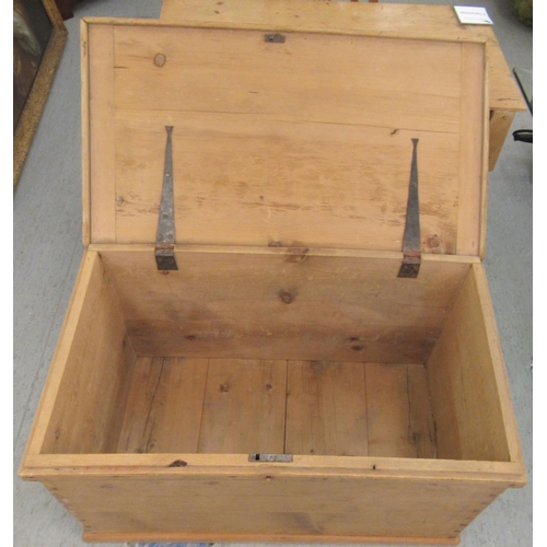 20 - An early 20thC boarded, waxed pine chest with straight sides and a hinged lid  21