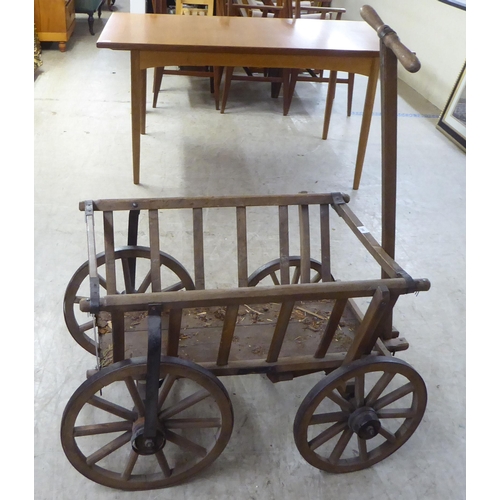 208 - An early 20thC dog cart with a T-bar handle and wrought iron rimmed wheels  32