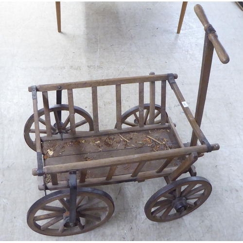 208 - An early 20thC dog cart with a T-bar handle and wrought iron rimmed wheels  32